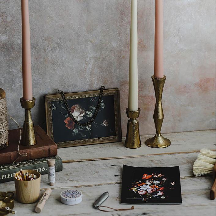 Connected Goods hand forged brass candlesticks in a moody vigentte with books and floral painting - minted.