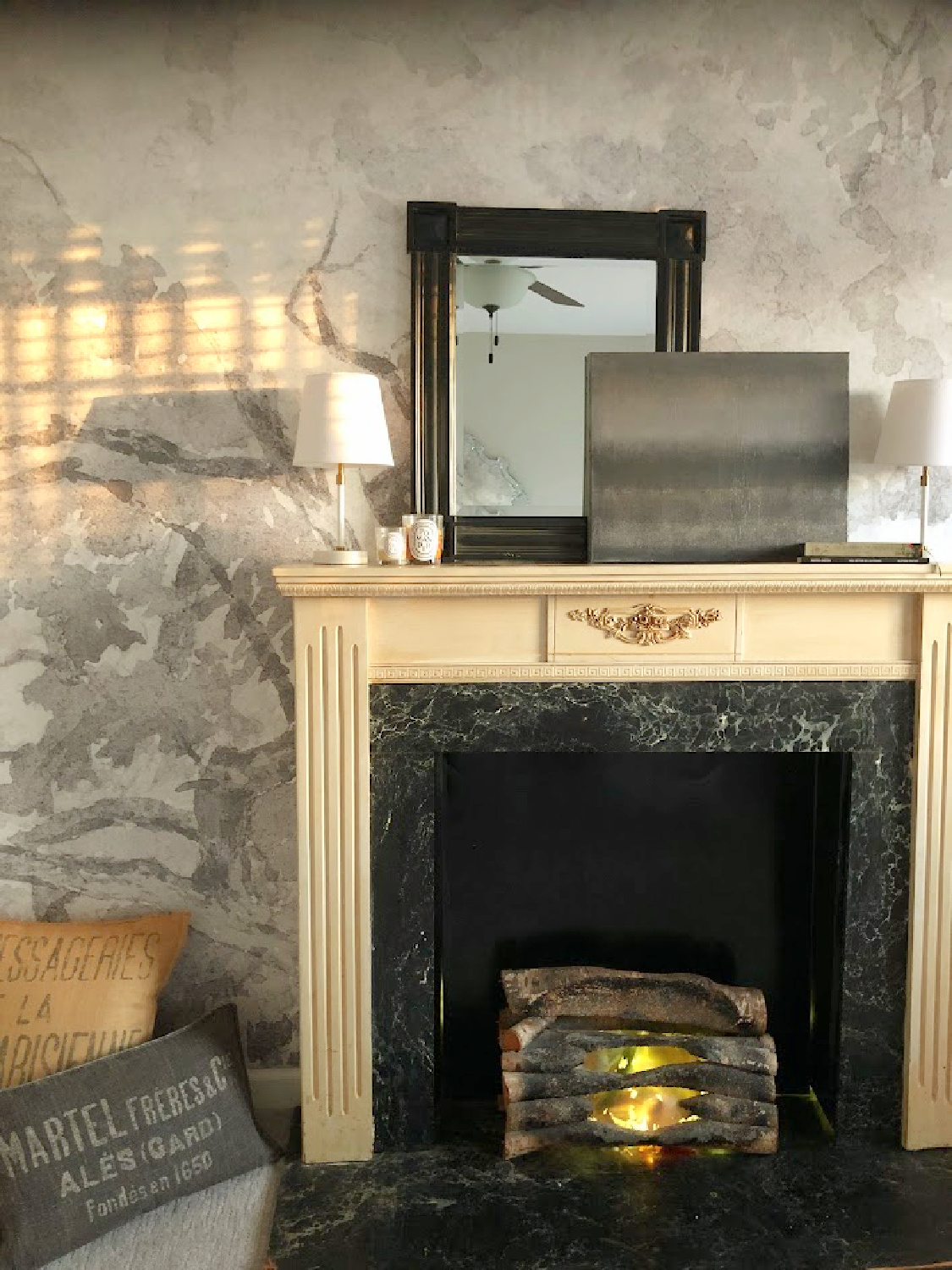 Faux fireplace in a guest bedroom with abstract grisaille mural - Hello Lovely Studio.