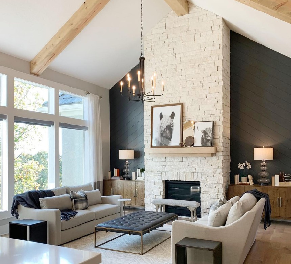 Iron Ore (Sherwin Williams) black on the shiplap flanking a stone fireplace in a beautiful modern rustic interior by @style.and.grace.interiors. #swironore #blackpaintcolors
