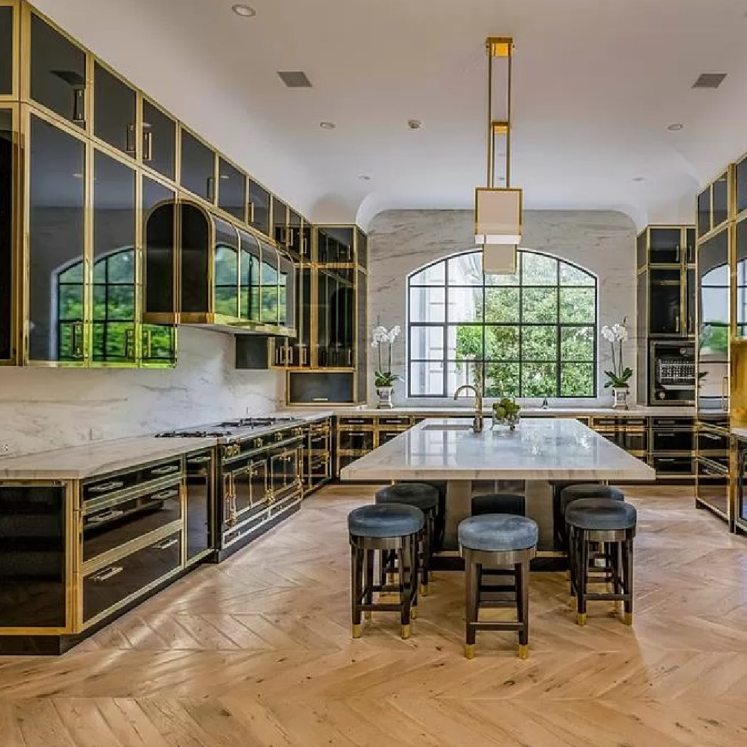 Breathtaking kitchen with Parisian cabinets, brass, chevron floors in Chateauesque French inspired Houston home (Willowick) with fantasy interiors. #fantasyhometour #luxuryhomes