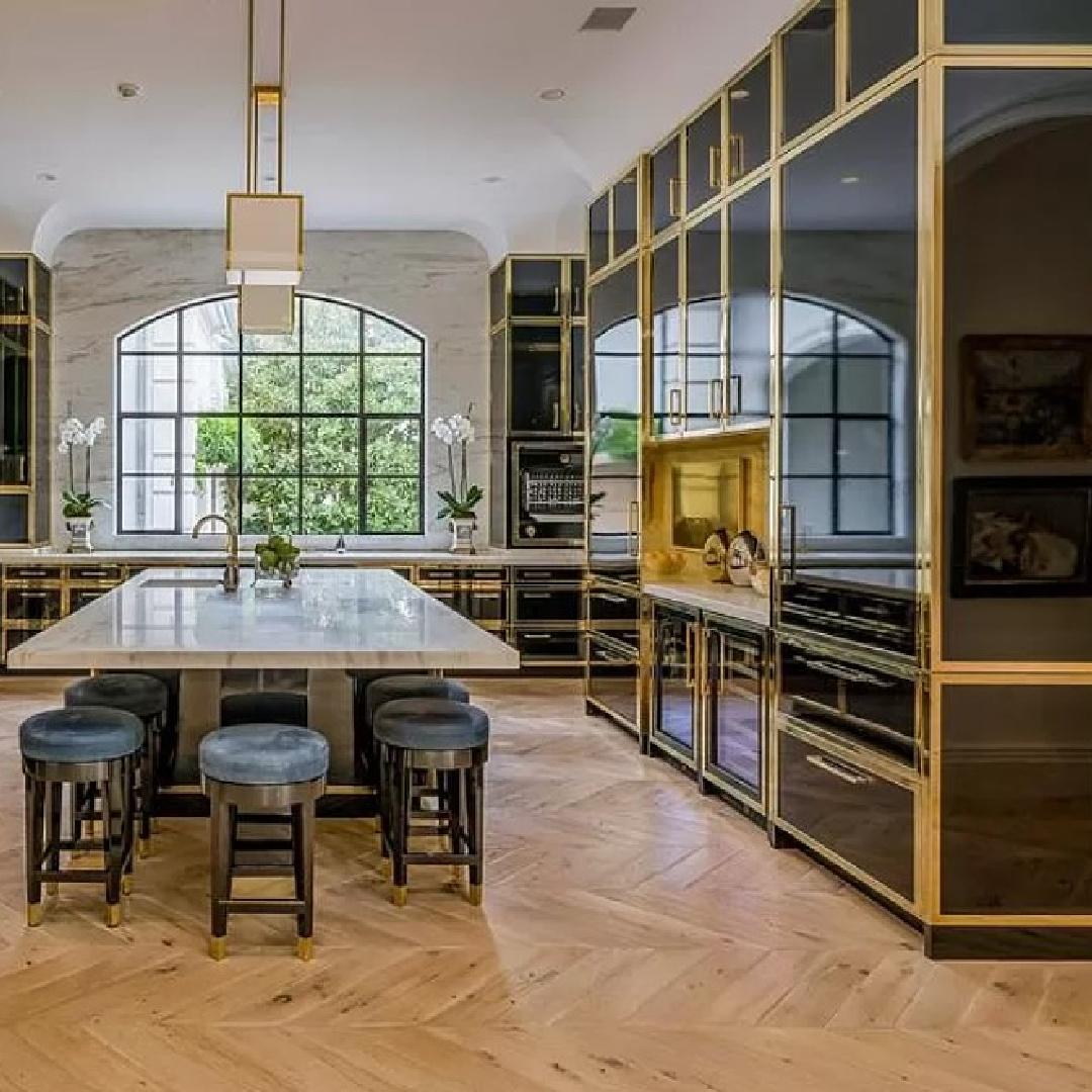 Breathtaking kitchen with Parisian cabinets, brass, chevron floors in Chateauesque French inspired Houston home (Willowick) with fantasy interiors. #fantasyhometour #luxuryhomes