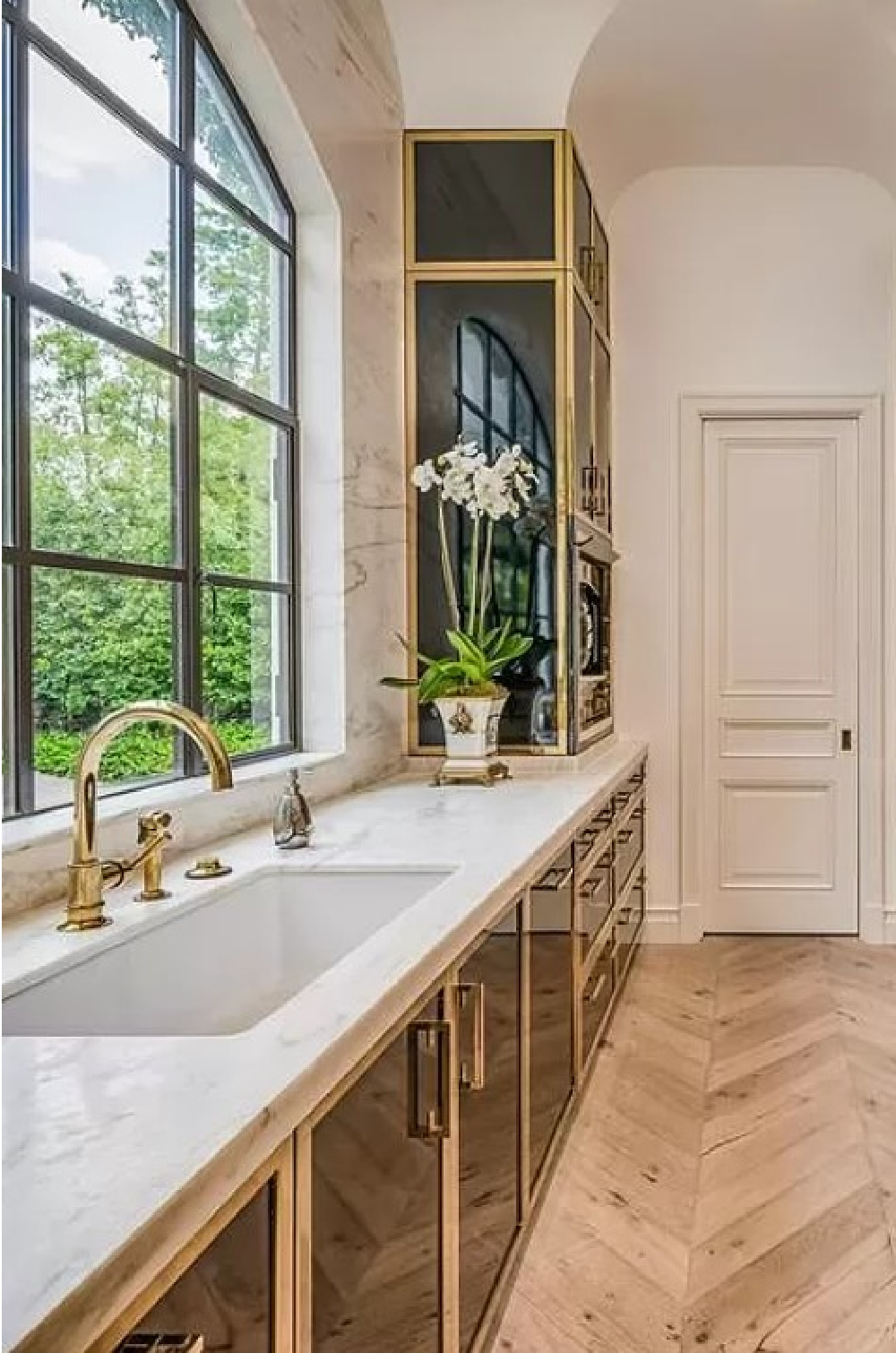 Breathtaking kitchen with Parisian cabinets, brass, chevron floors in Chateauesque French inspired Houston home (Willowick) with fantasy interiors. #fantasyhometour #luxuryhomes