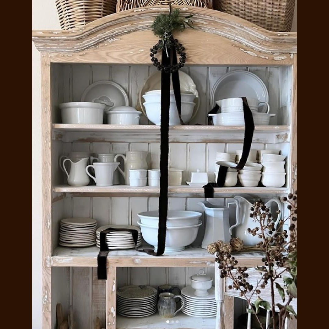 Understated chocolate brown ribbon on a pale wood cupboard makes a lovely French country Christmas moment by Dore of BurlapLuxe.