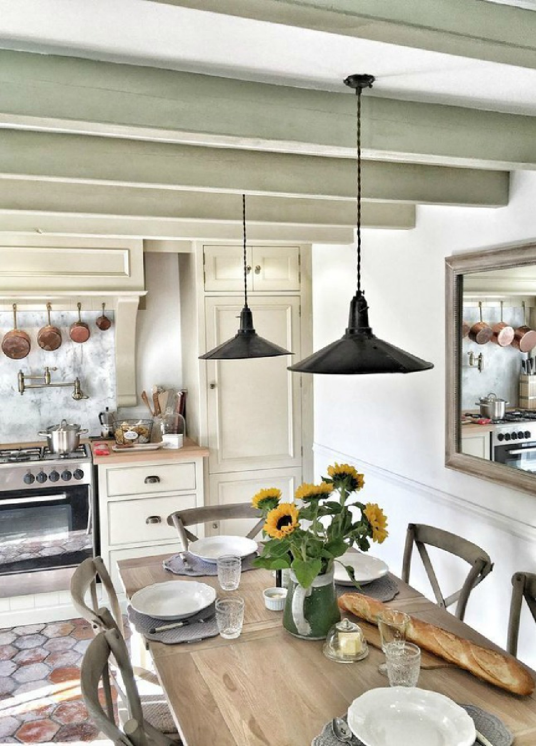 French farmhouse kitchen with rustic ceiling beams, terracotta tile floor, and limestone painted cabinetry - Vivi et Margot. #frenchkitchens #frenchfarmhouse