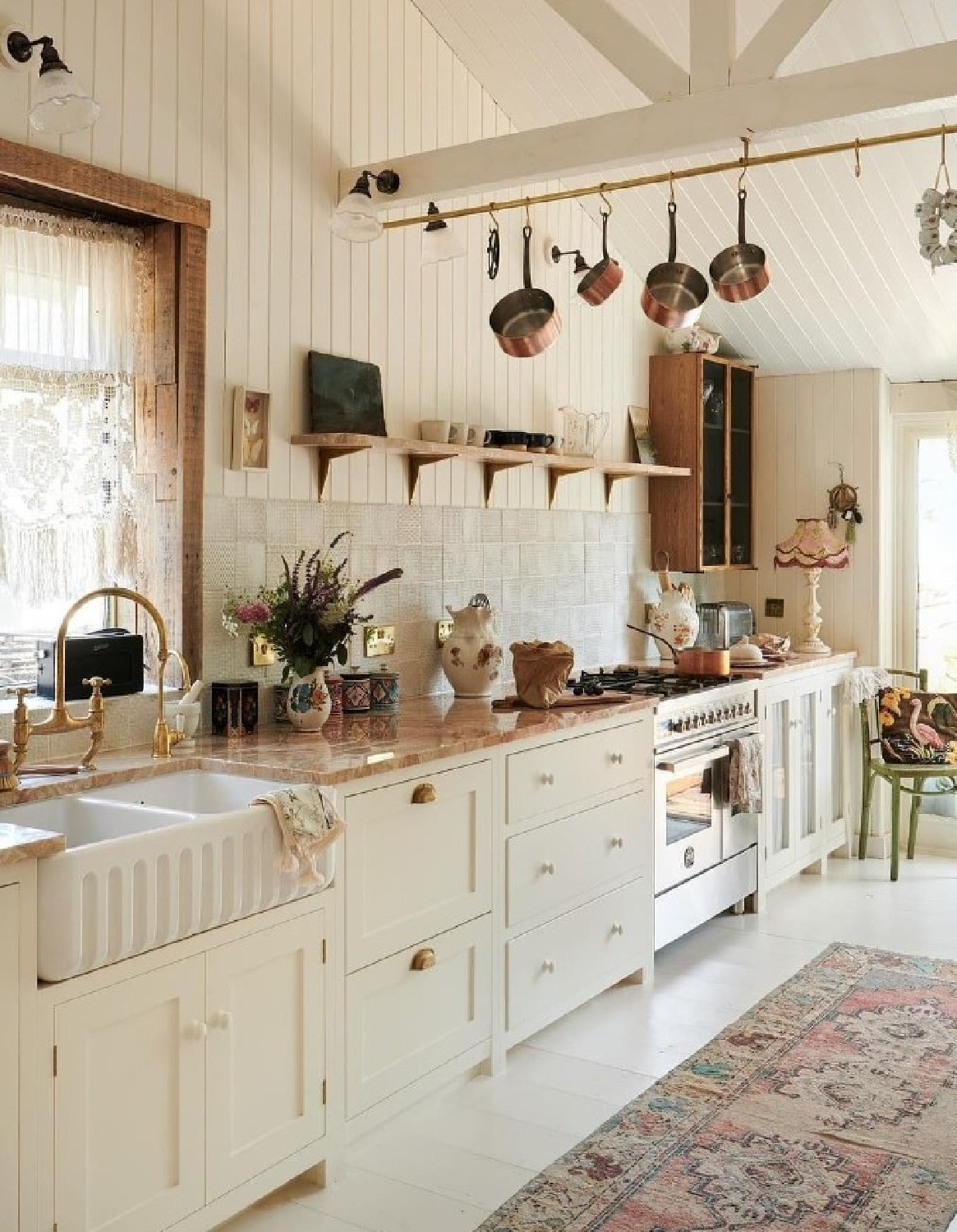 deVOL Kitchens beautiful English country bespoke kitchen with pale colors, brass pot rack, and touches of rose. #devolkitchens