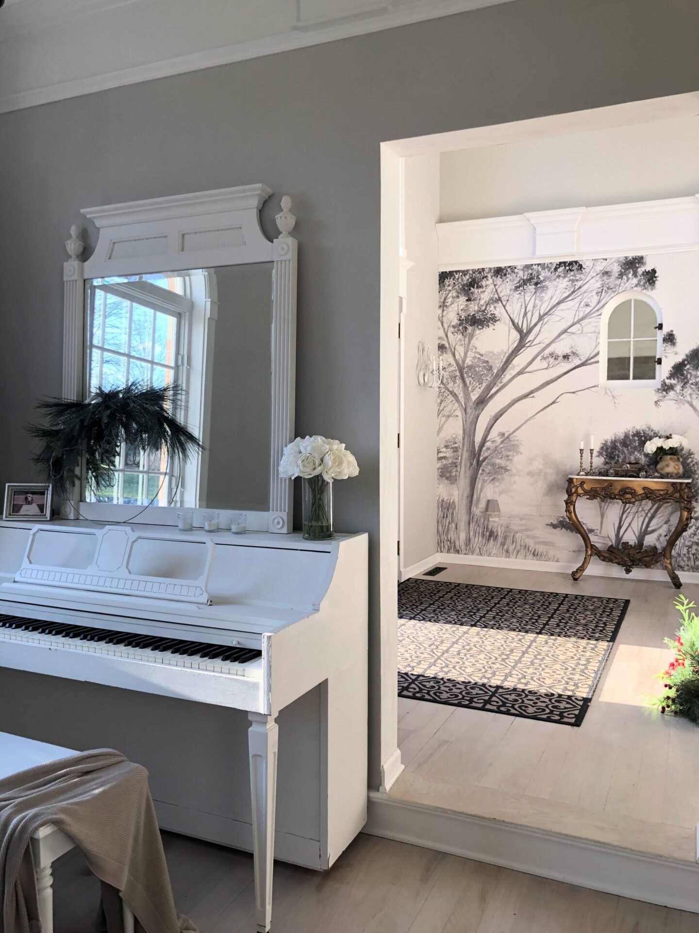 Hello Lovely's holiday foyer with tree mural and modern French serene mood.