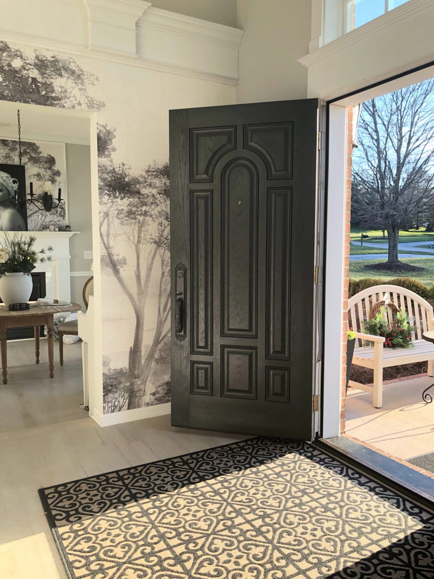 Hello Lovely's holiday foyer with tree mural and modern French serene mood.