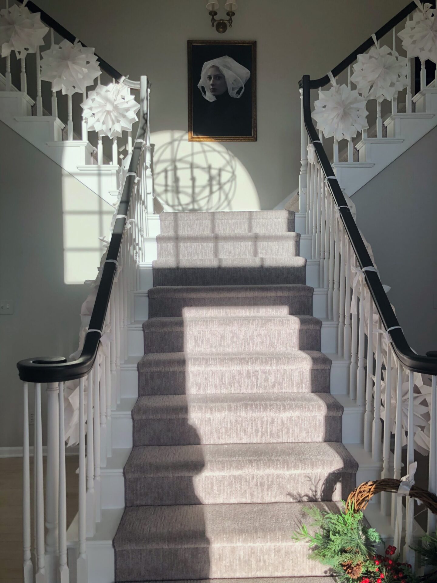 Hello Lovely's white paper bag snowflake holiday garland on fancy staircase for 2023. #snowflakegarland #papersnowflakes #paperbagsnowflakes