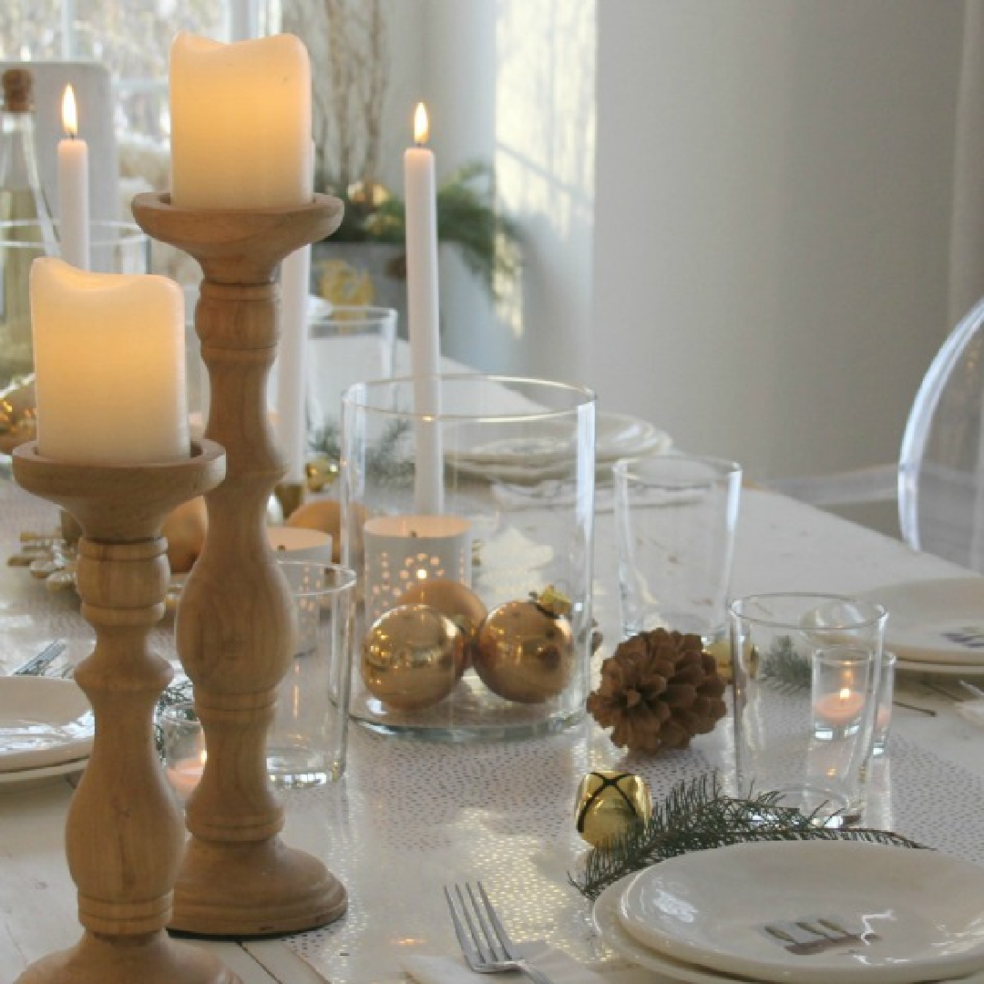 Rustic candleholders, gold bulbs, and candles on my white farmhouse table for Christmas - Hello Lovely Studio. #christmastablescape #hellolovelychristmas #whiteandgold