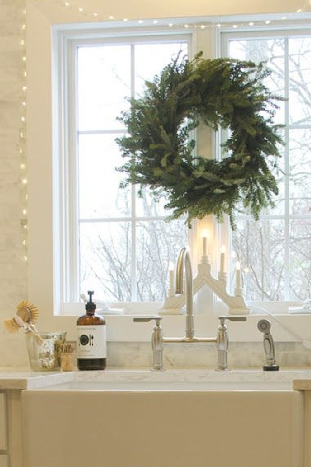 Fraser Fir wreatch and Swedish wooden candelabra at my kitchen farm sink - Hello Lovely. #farmhousechristmas #scandichristmas #hellolovelychristmas