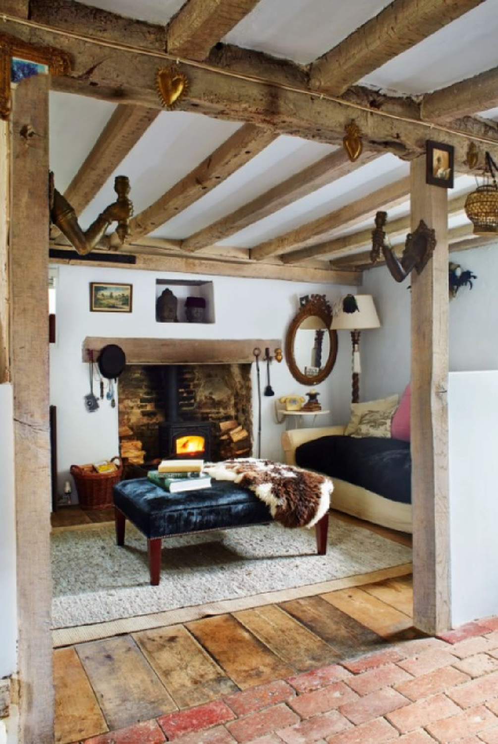 Rustic wood beams and weathered floors in a Sussex farmhouse snug room by Harriet Anstruther (photo: Ngoc Minh Mgo fin House & Garden UK). 
