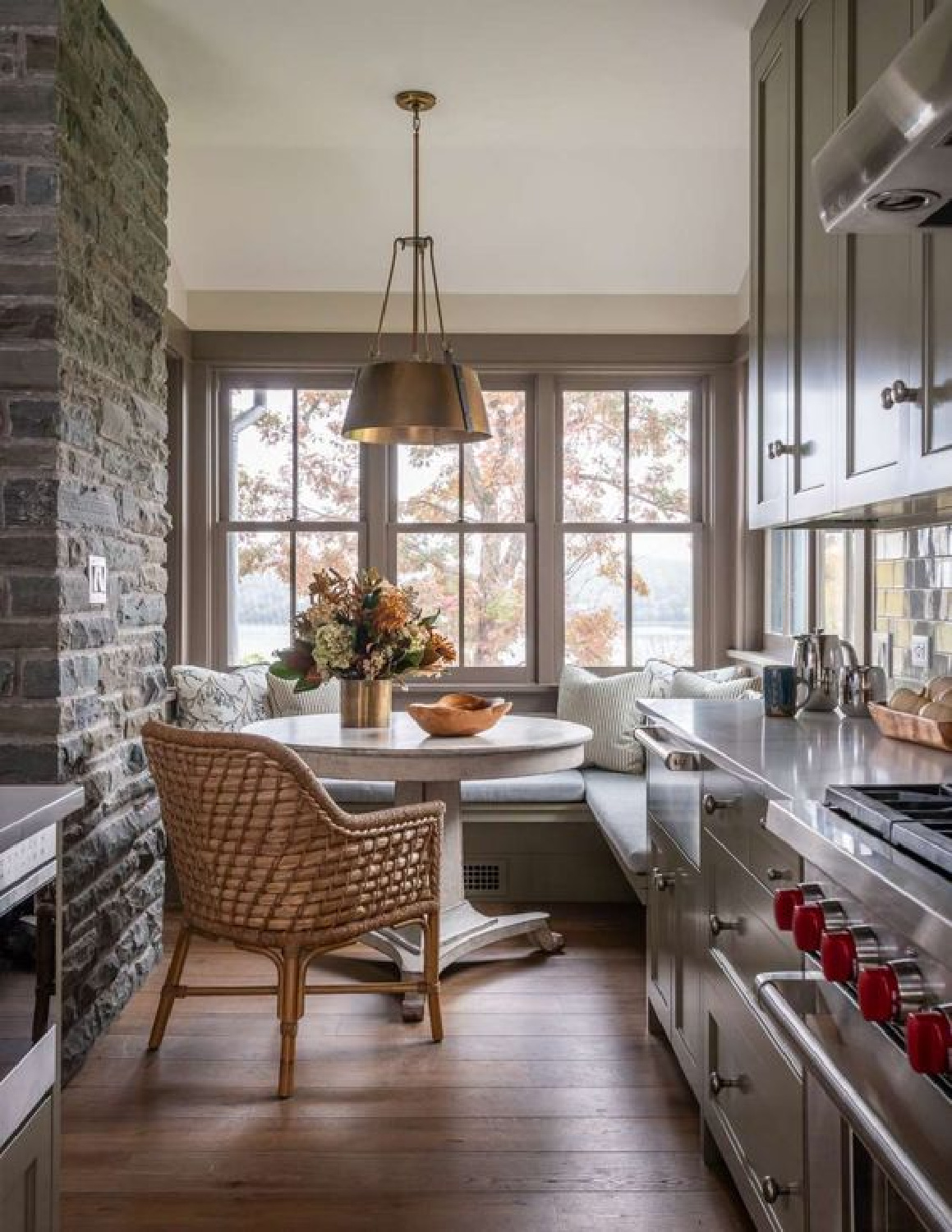 JLF Architects - cozy breakfast nook with built-in benches and round table overlooking water in galley style kitchen.