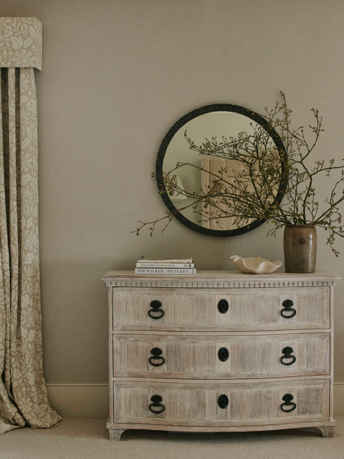 Sims Hilditch designed timeless serene bedroom with beautiful dresser and round mirror in a Cotswold manor home. #timelessdesign #romanticbedrooms #europeancountry #cotswoldshomes