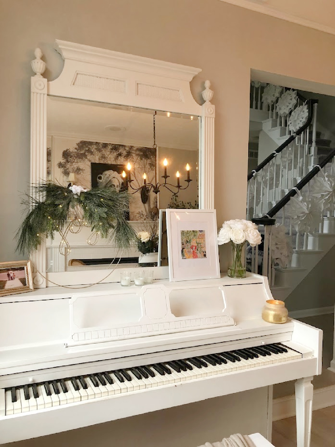 Hello Lovely white Christmas 2024 with snowflake garland on stairs and white piano in dining room. #hellolovelyhome