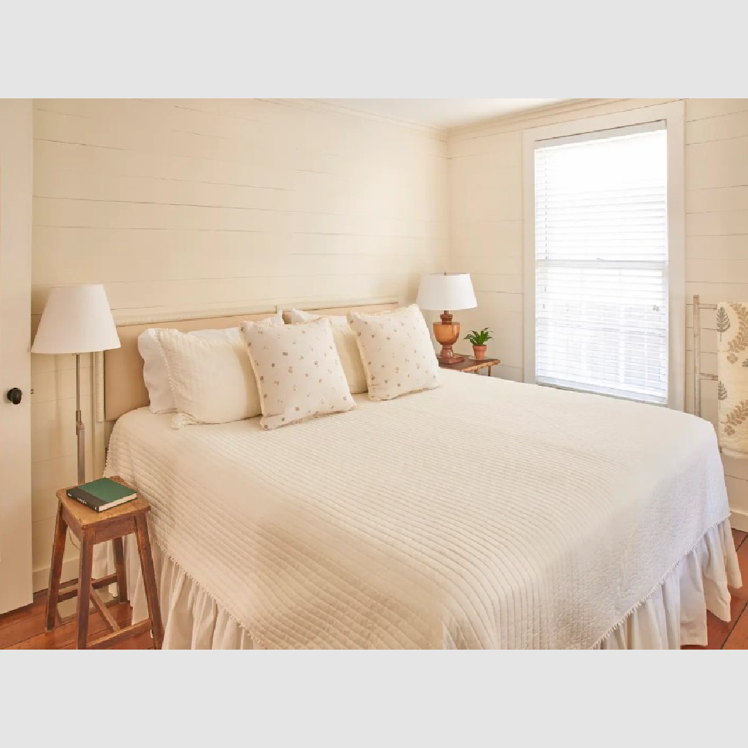 Low country cottage bedroom with shiplap and wood floors in a 1889 renovated cottage in Southern Living.