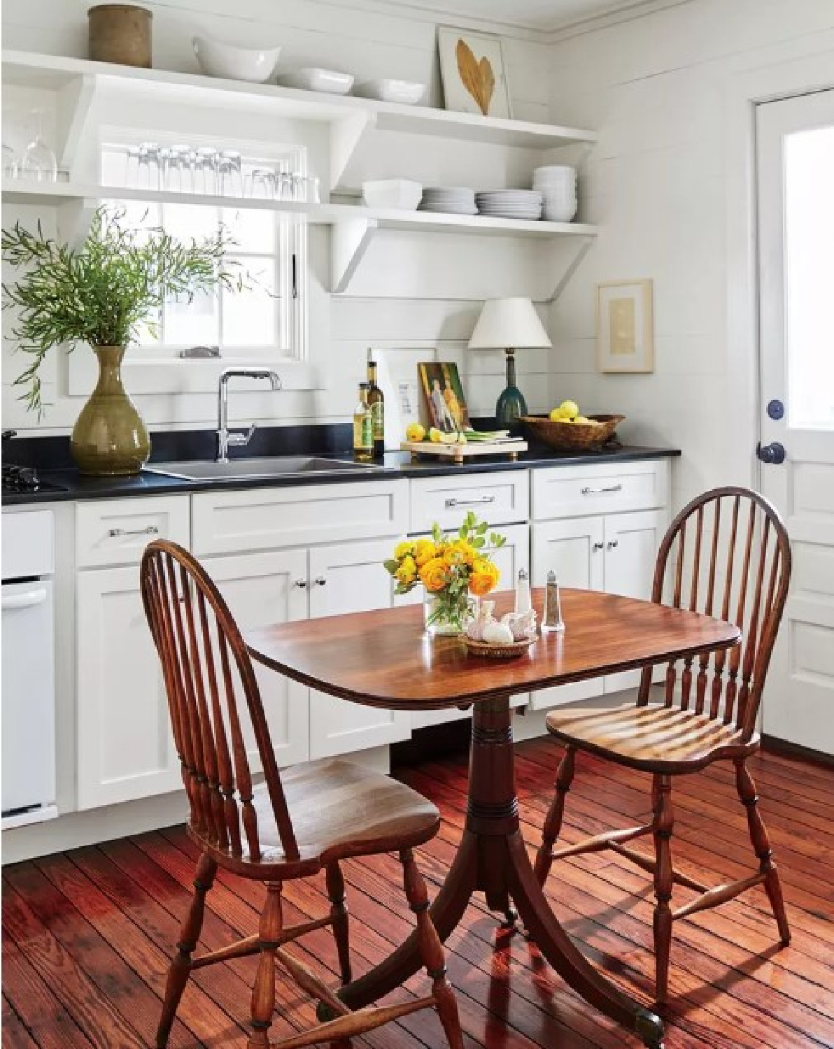 White country cottage kitchen with shiplap, black counters and open shelving - Southern Living.