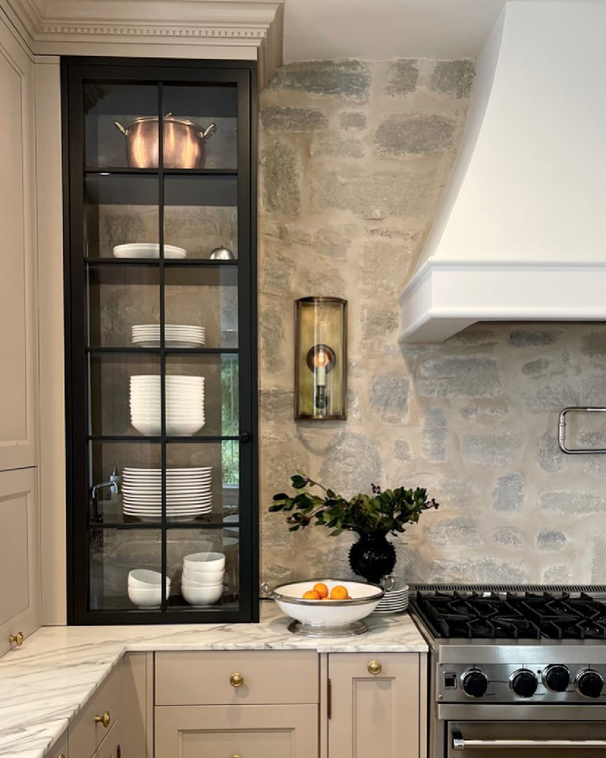 Farrow & Ball Jitney on base cabinets with black glass front cabinet in a lovely timeless kitchen with stone backsplash - @m_m_interior_design. #farrowandballjitney