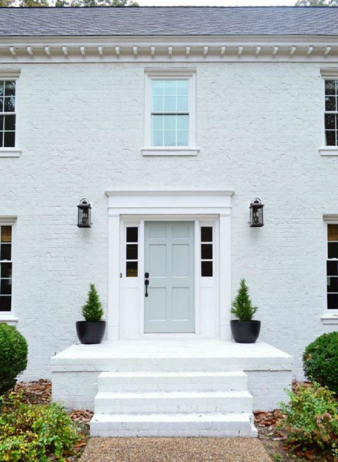 Moderne White (Sherwin Williams) on a painted brick house exterior - Young House Love. Door is Benjamin Moore Tranquility. #whitebrickhouse #modernewhite #swmodernewhite #benjaminmooretranquility