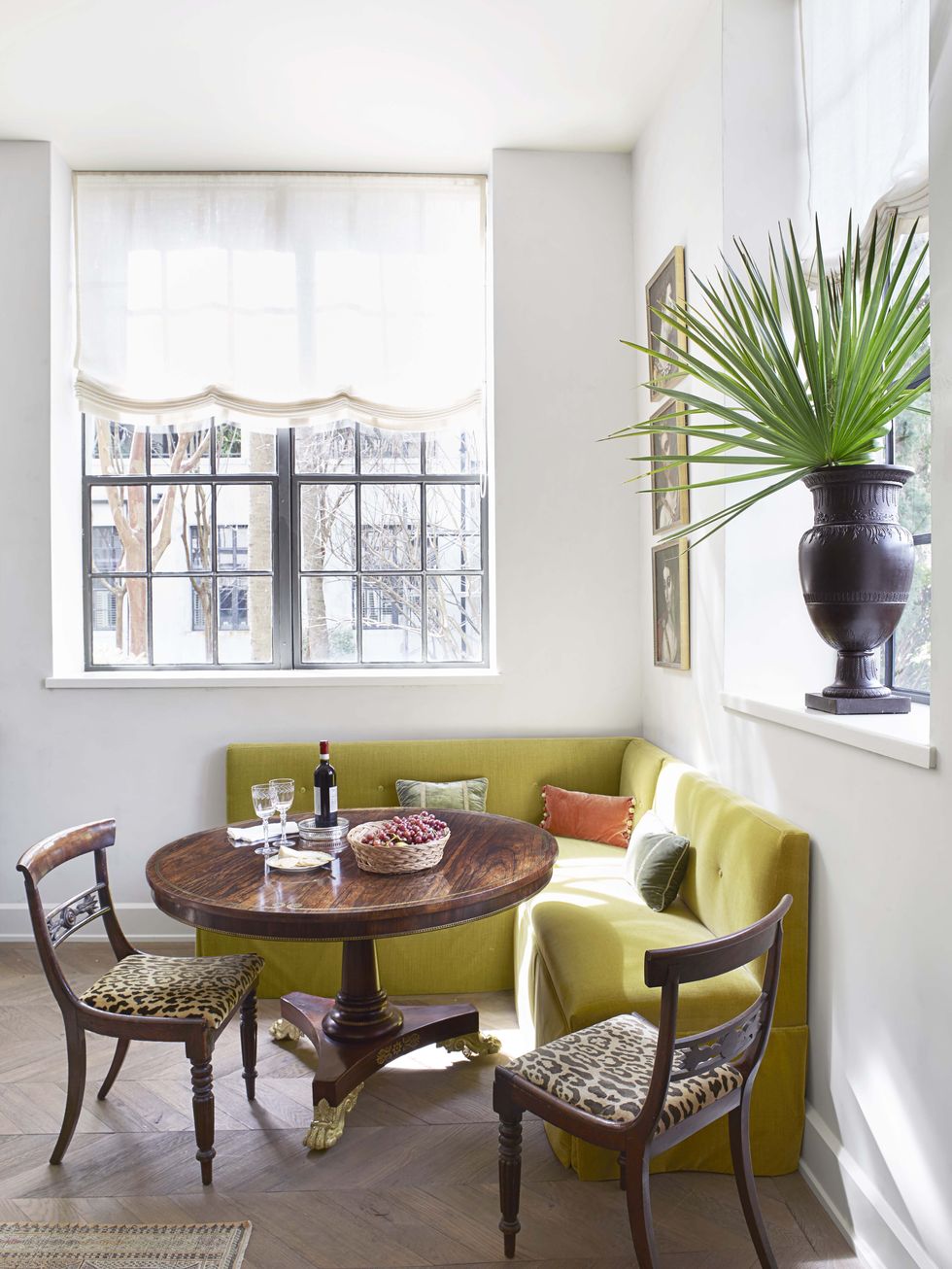 Chartreuse banquette in Amelia Handegan designed breakfast nook with antique round table and animal print covered chairs - Veranda.