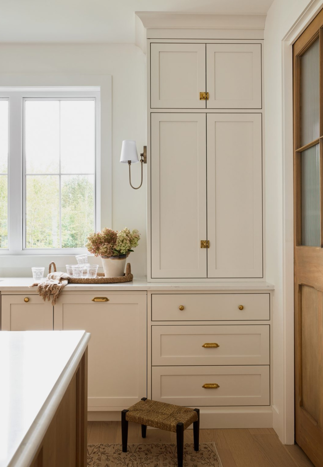 Benjamin Moore PALE OAK on kitchen cabinets in a gorgeous warm, European inspired luxe kitchen by AKB Design. #benjaminmoorepaleoak #warmwhitekitchen #whitekitchencabinetcolor