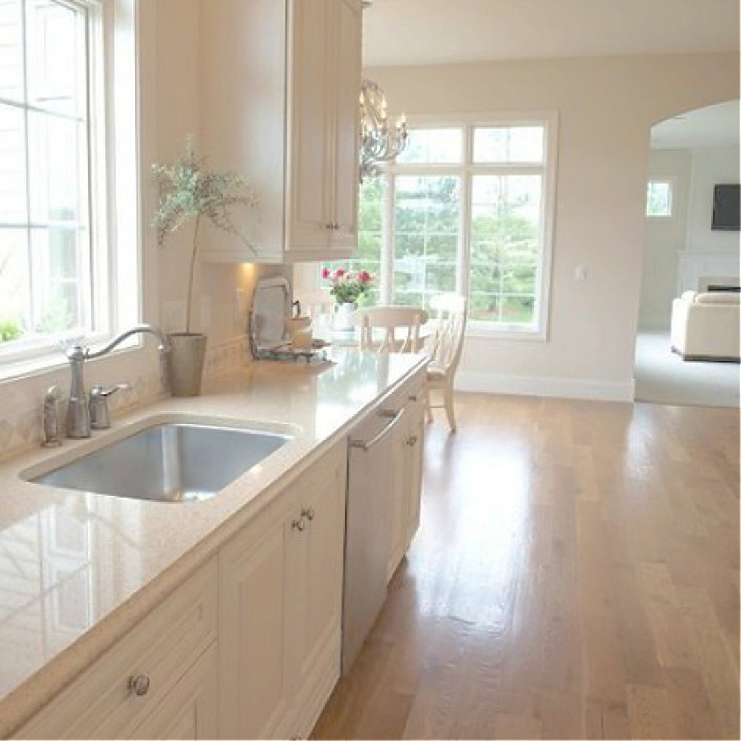 Warm white French country kitchen with white oak hardwood floors and quartz counters - Hello Lovely Studio. #benjaminmoorewhitesand