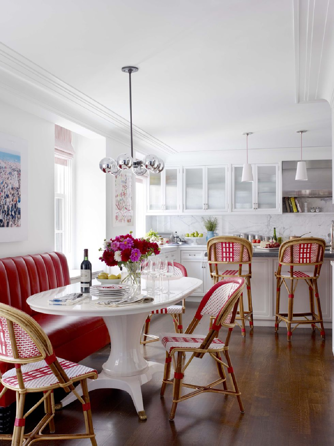 Red accents in a white kitchen by Celerie Kemble with breakfast nook and banquette - Francesco Lagnese for Veranda.