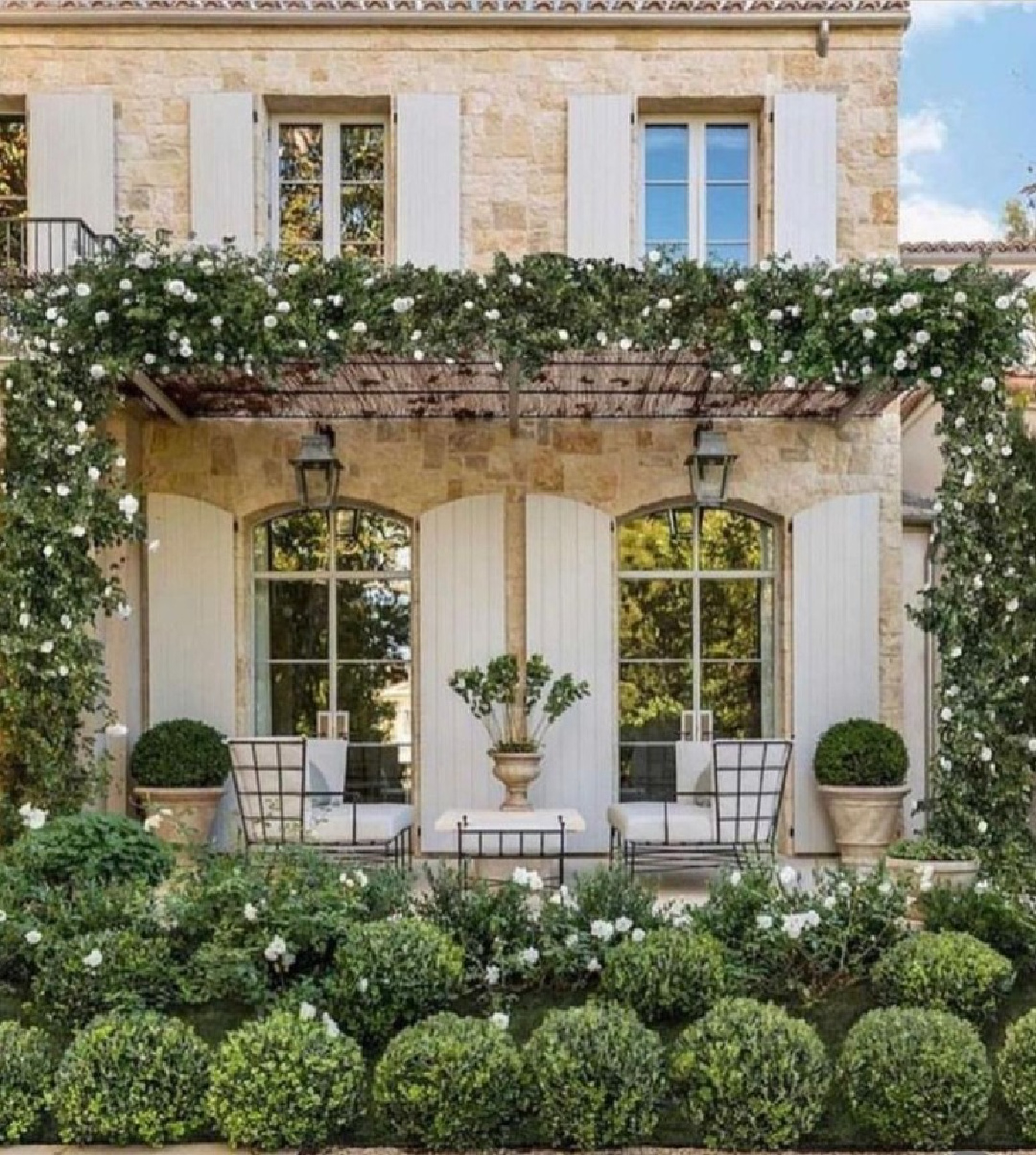 Giannetti Home designed stone French home with shutters and climbing roses looks straight out of Provence! @giannettihome #stevegiannetti #brookegiannetti #patinahomes