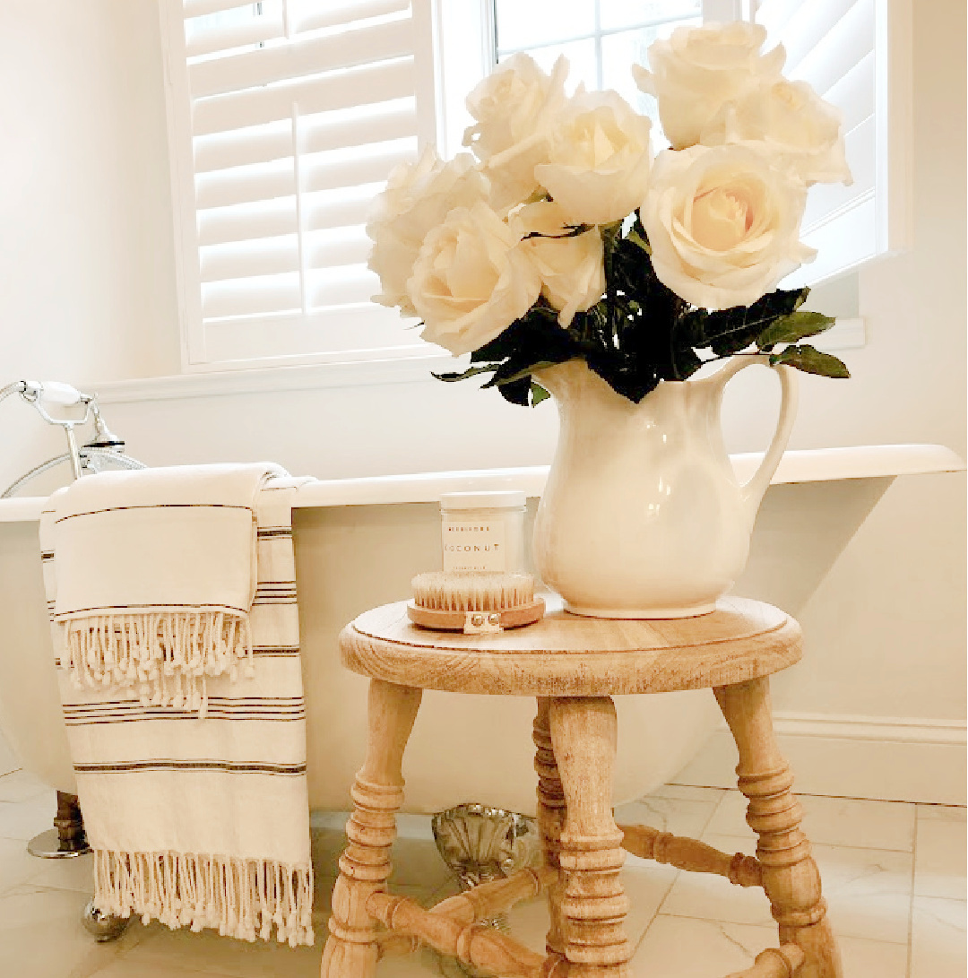 Hello Lovely's modern French white bathroom with clawfoot tub and white roses. #modernfrench #hellolovelyhome
