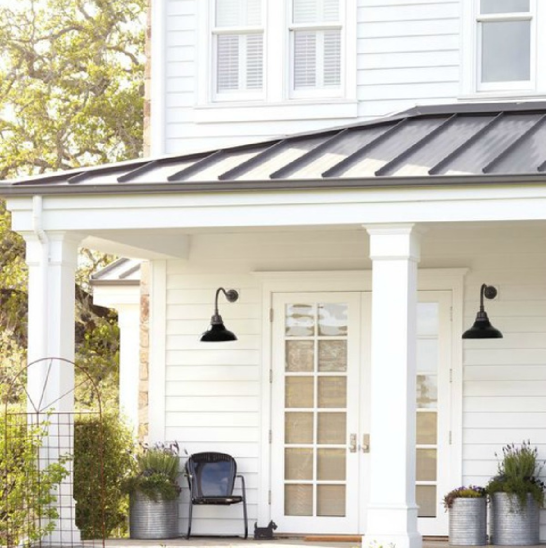 White modern farmhouse exterior with porch and black farmhouse outdoor wall sconces - Rejuvenation. #modernfarmhouseexterior #countryporches #outdoorwallsconce