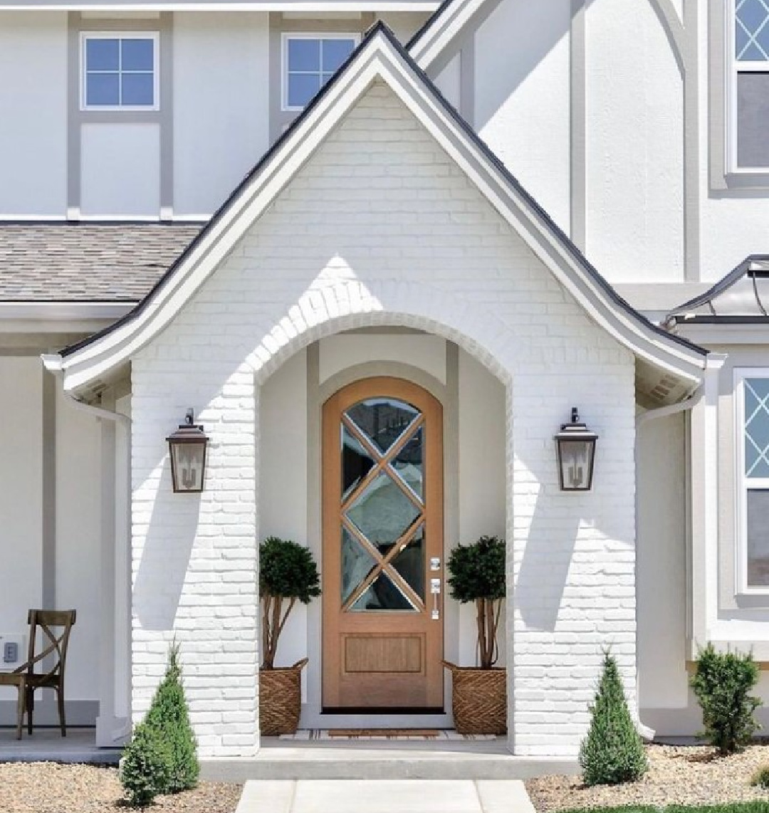 Sherwin-Williams GREEK VILLA on a brick tudor-style exterior - @clarkandcohomes. #sherwinwilliamsgreekvilla #whitehouseexteriors #whitehousecolors