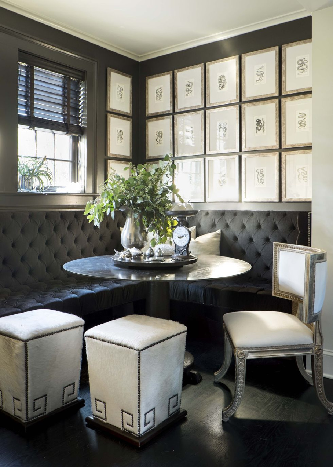 Rich and dark tufted built-in tufted banquette restaurant style seating in Susan Ferrier designed dining nook with gallery of framed art - Veranda.