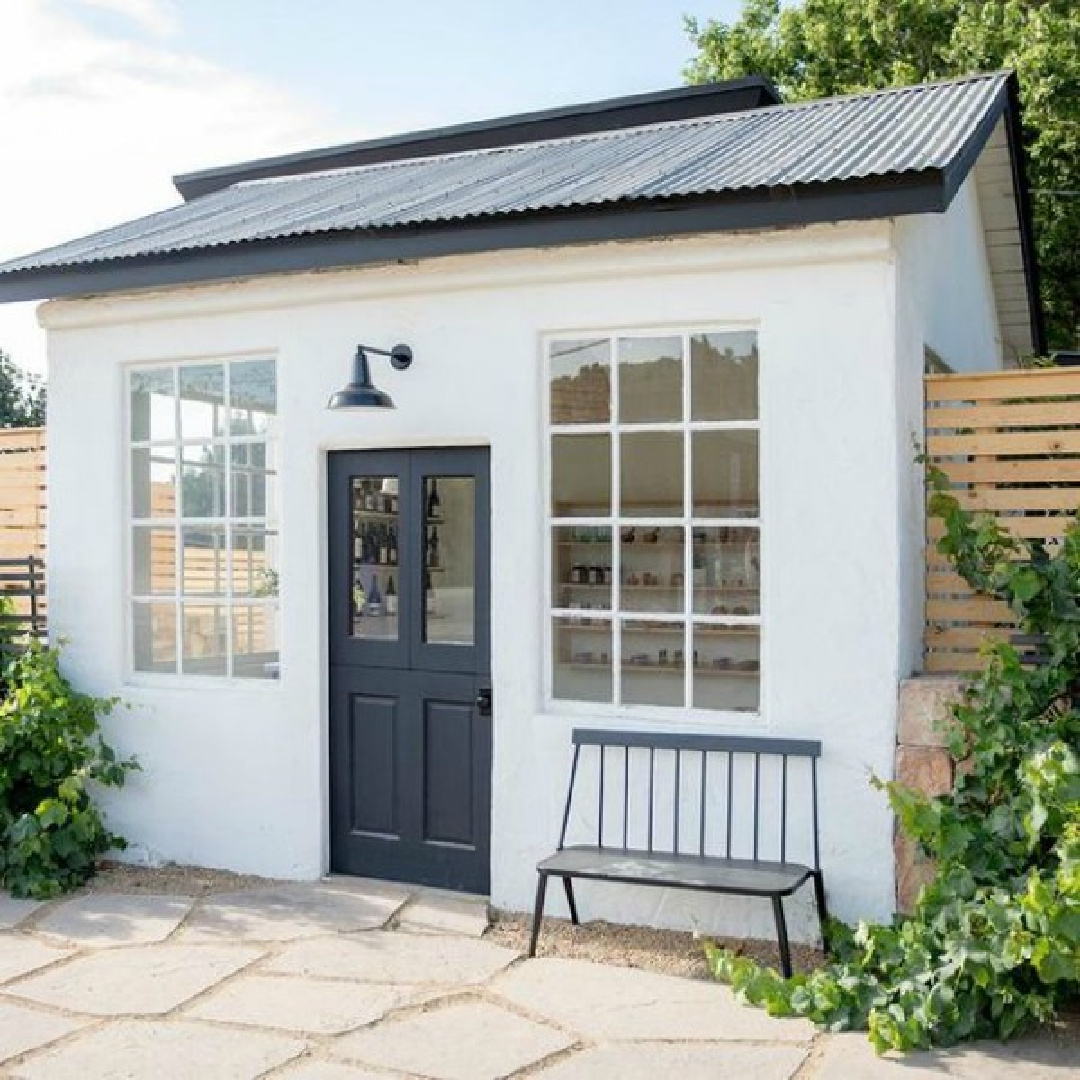 Try a white such as BM Chantilly Lace or Farrow & Ball All White for this look. Small white shop or studio with black Dutch door and farmhouse bench - via Schoolhouse.