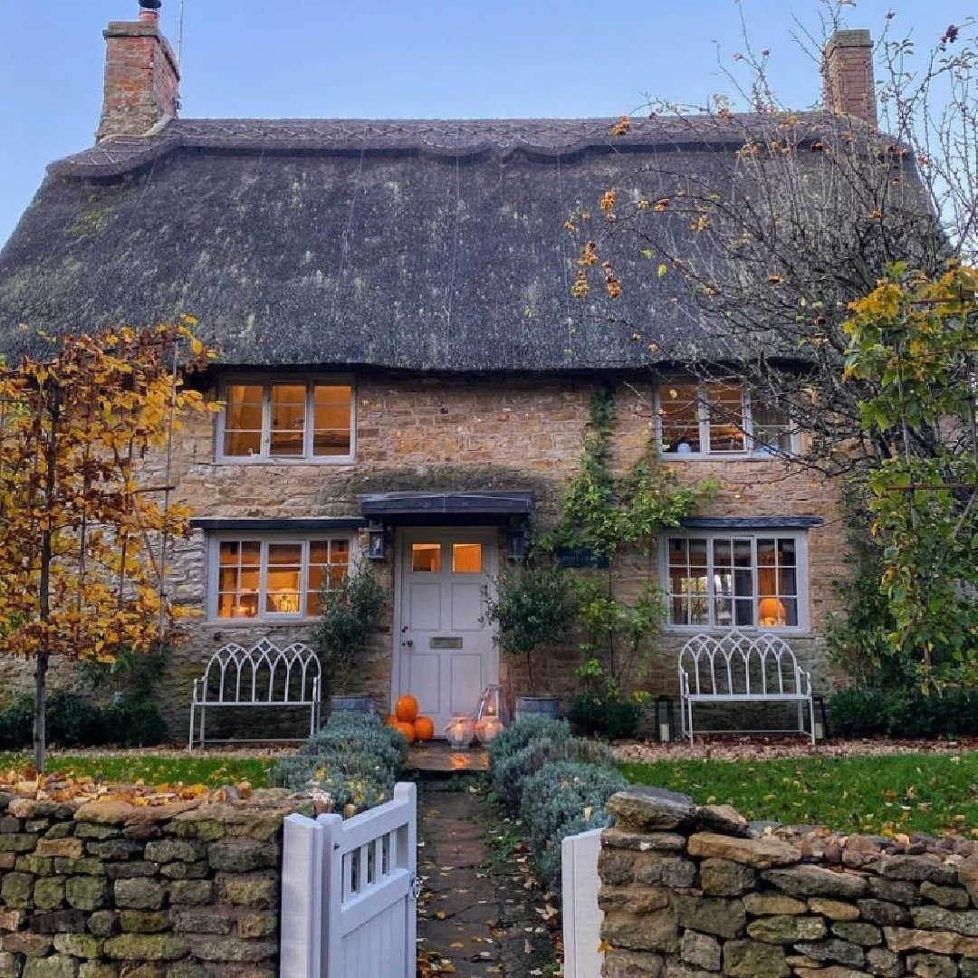 Osborn Interiors award winning English country cottage in the Cotswolds with thatched roof, stone walls, and a charming gate. #cotswoldcottage #englishcountry