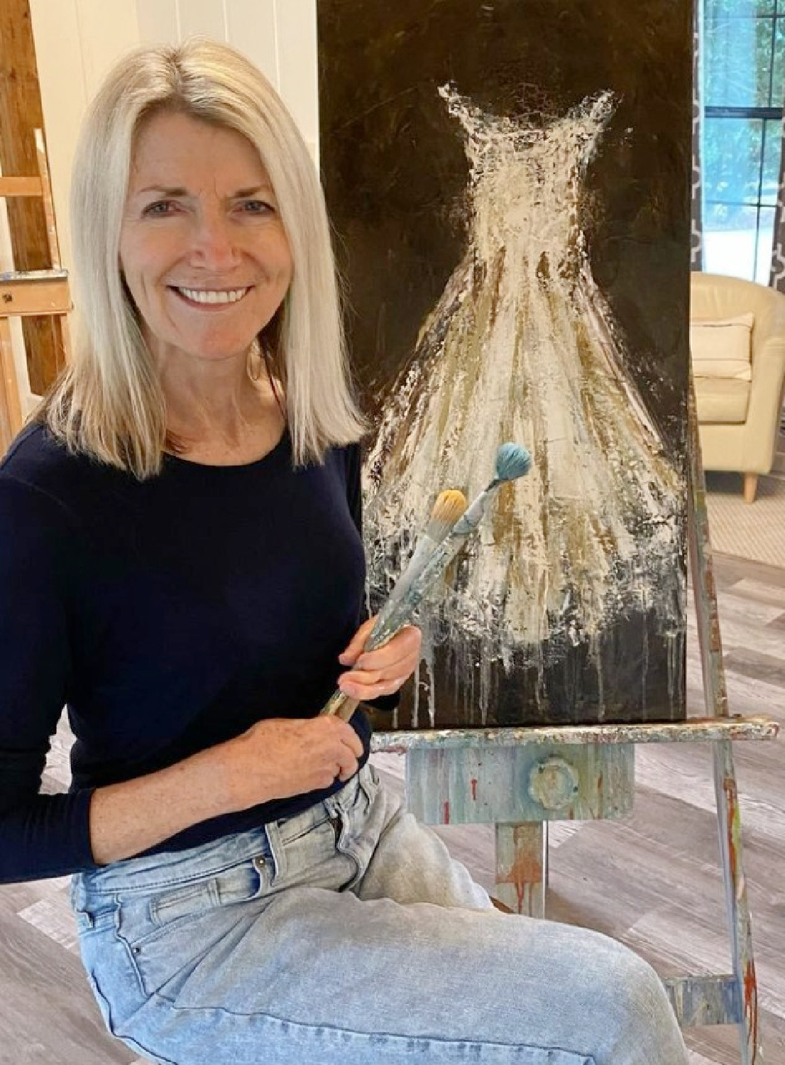 Holly Irwin with one of her fine art paintings of a white gown.