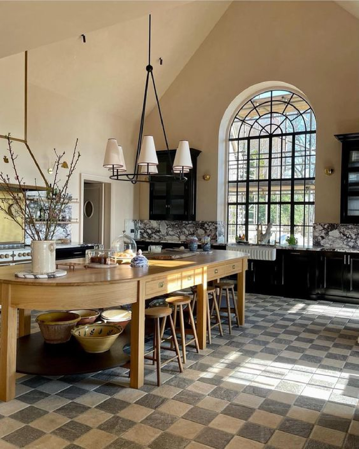 BarlowandBarlow designed European country kitchen with checkered floor and arched window. #europeankitchen