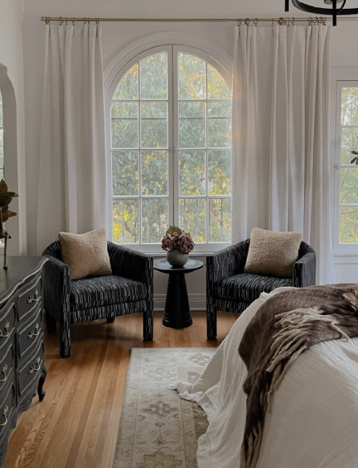 Lone Fox (Drew Michael Scott) designed bedroom with sitting area near arched window in a California Spanish style home.