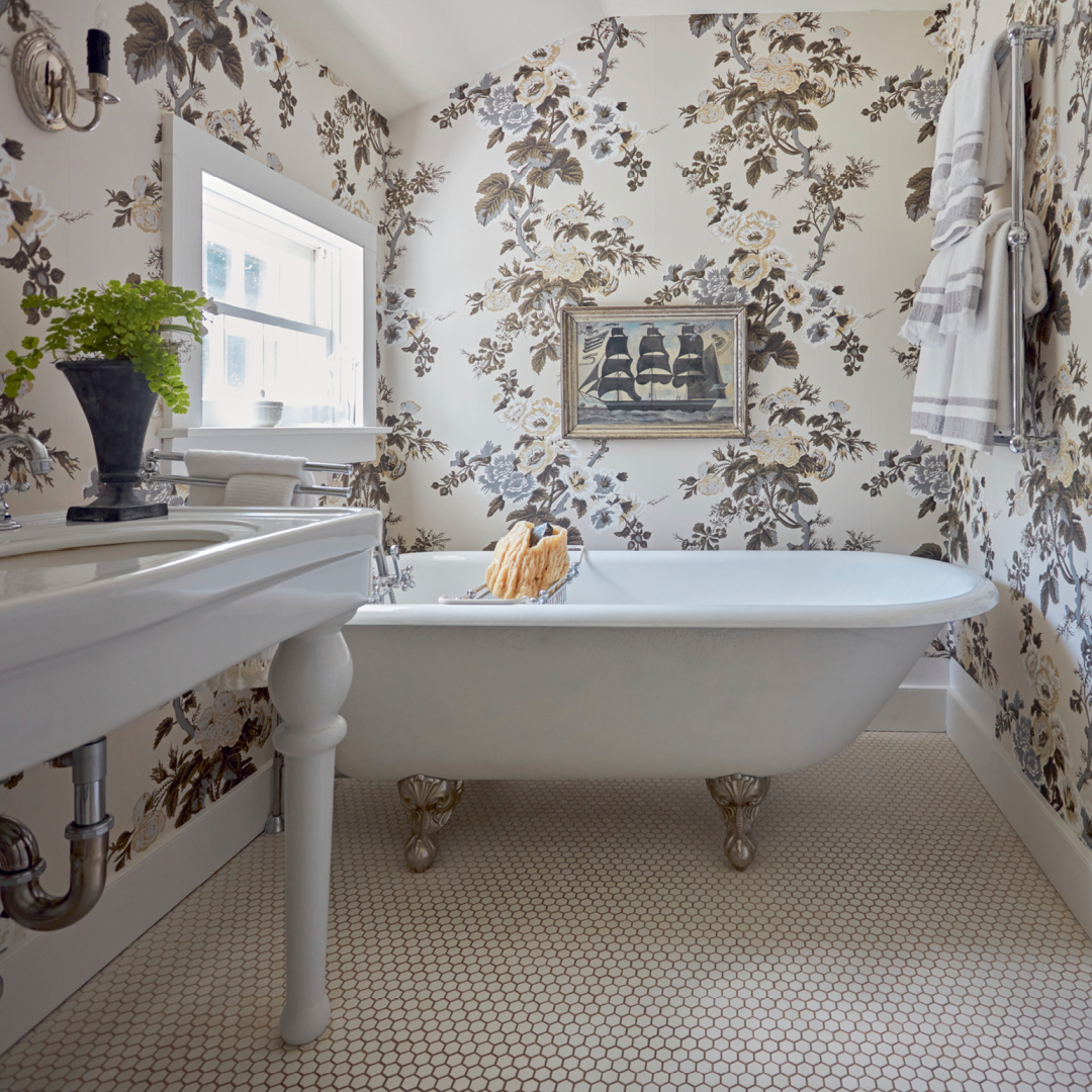 Bath with Schumacher Pyne Hollyhock wallpaper and clawfoot tub in Nora Murphy COUNTRY HOUSE LIVING. #newenglandstyle #americancountry #pynehollyhock
