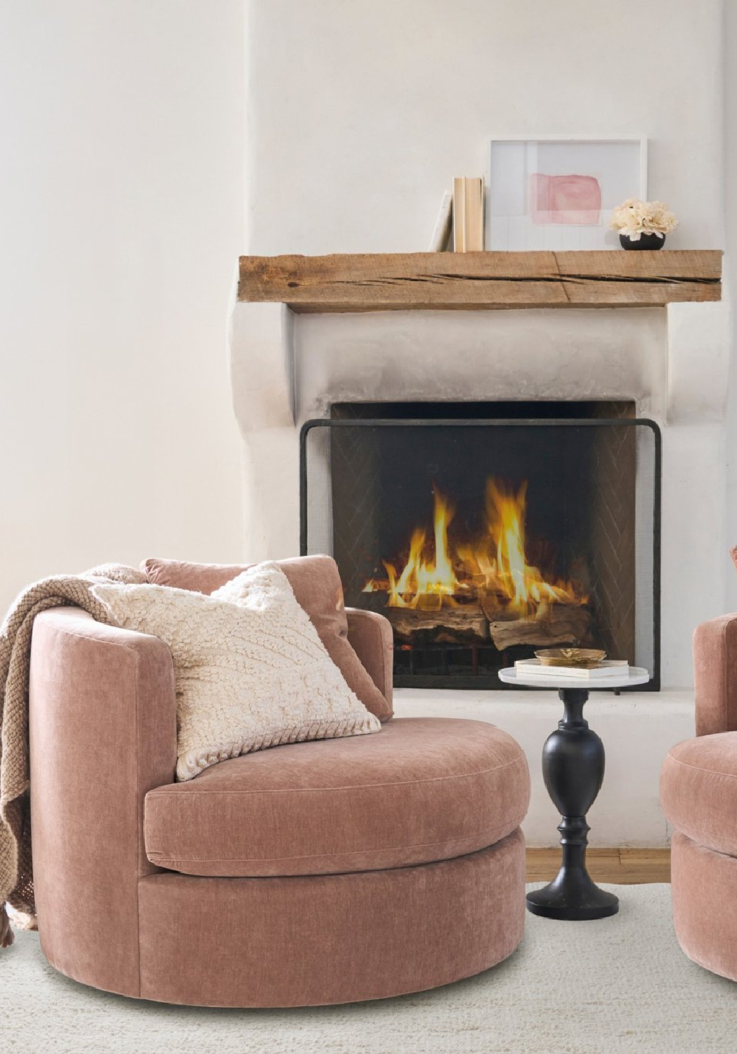 Rose velvet swivel chair near fireplace, Pottery Barn.