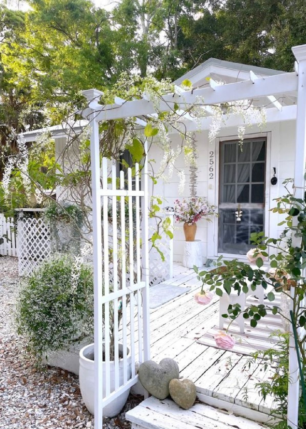 Fifi O'Neill's charming white romantic cozy Florida cottage front porch and gardens.