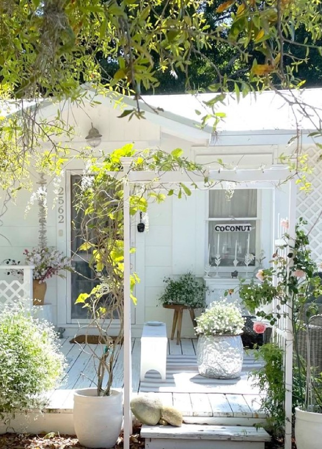 Fifi O'Neill's charming white romantic cozy Florida cottage front porch and gardens.