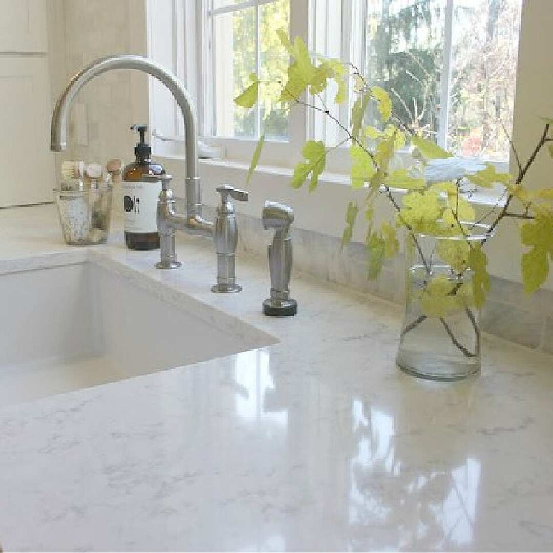 Minuet quartz countertops (Viatera) in Hello Lovely's white Shaker kitchen with farm sink. #minuetquartz #whitequartzcountertop #viaterausa