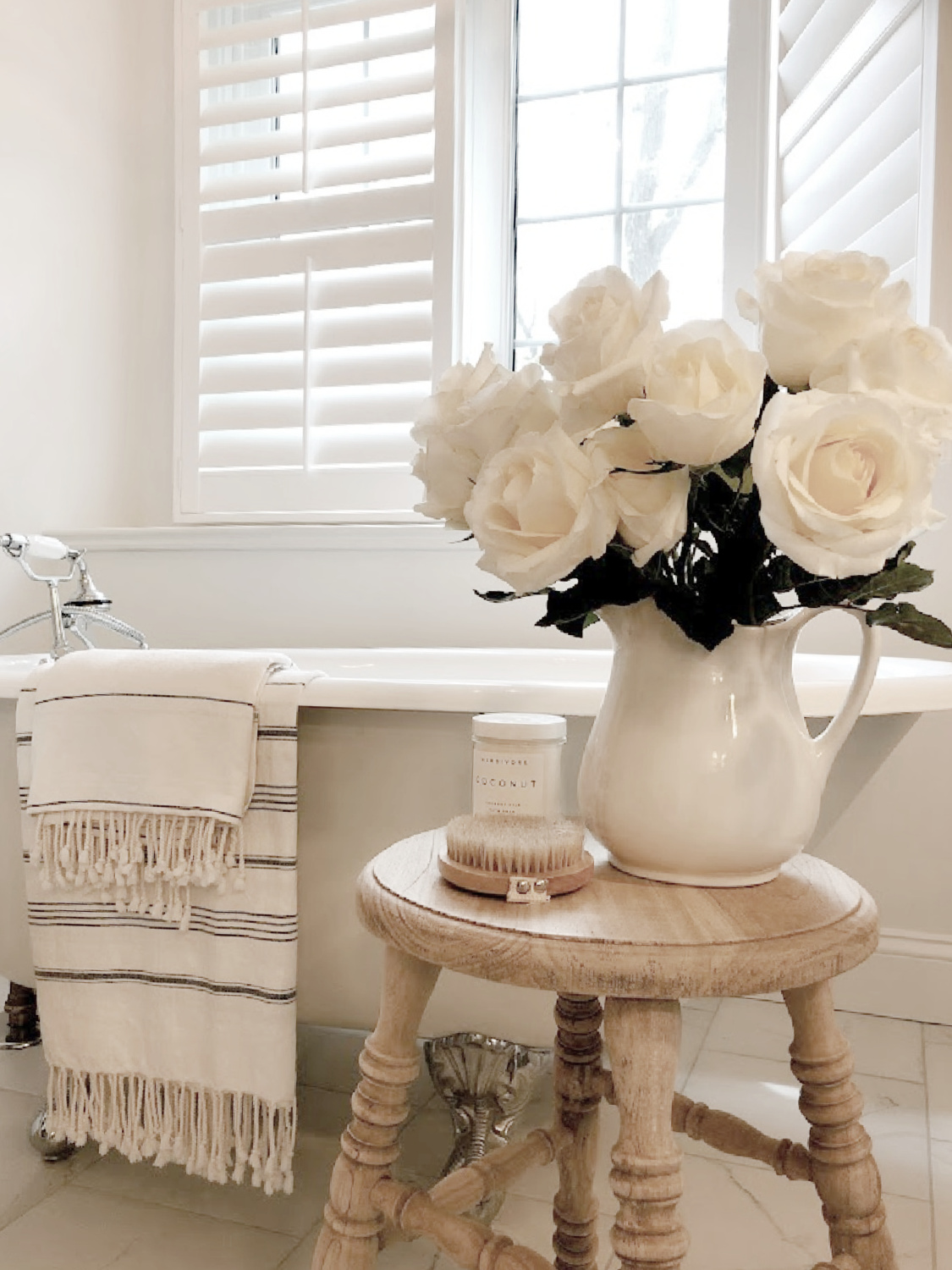 Hello Lovely's modern French bath with clawfoot tub and white roses. #modernfrench