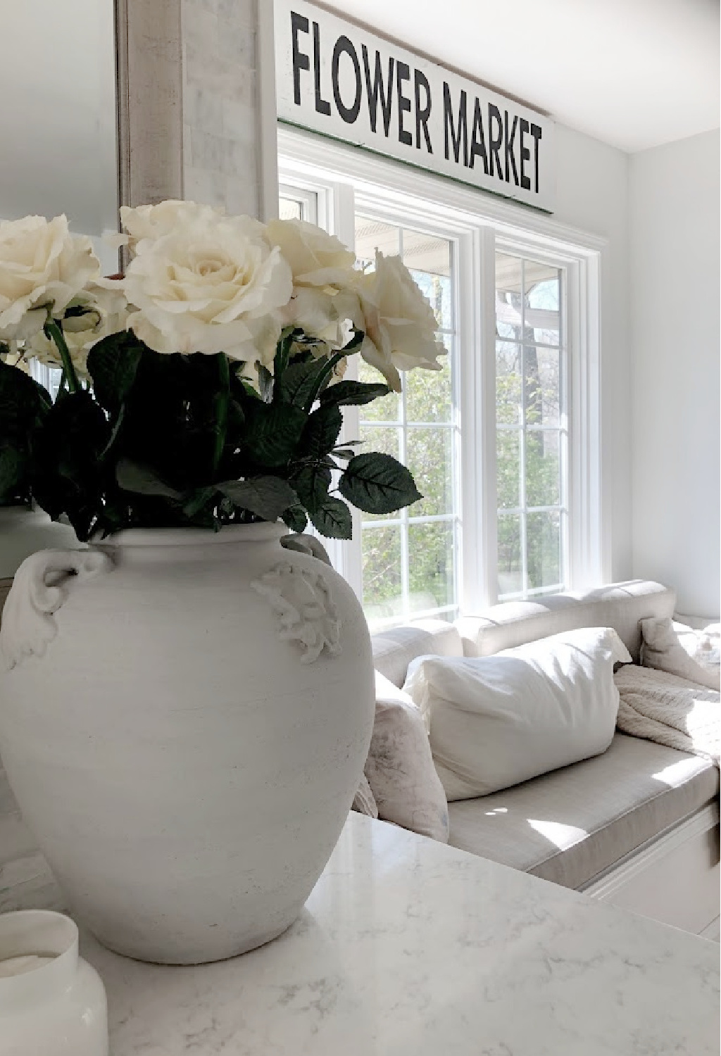 Terracotta urn with white roses on my counter near window seat - Hello Lovely.