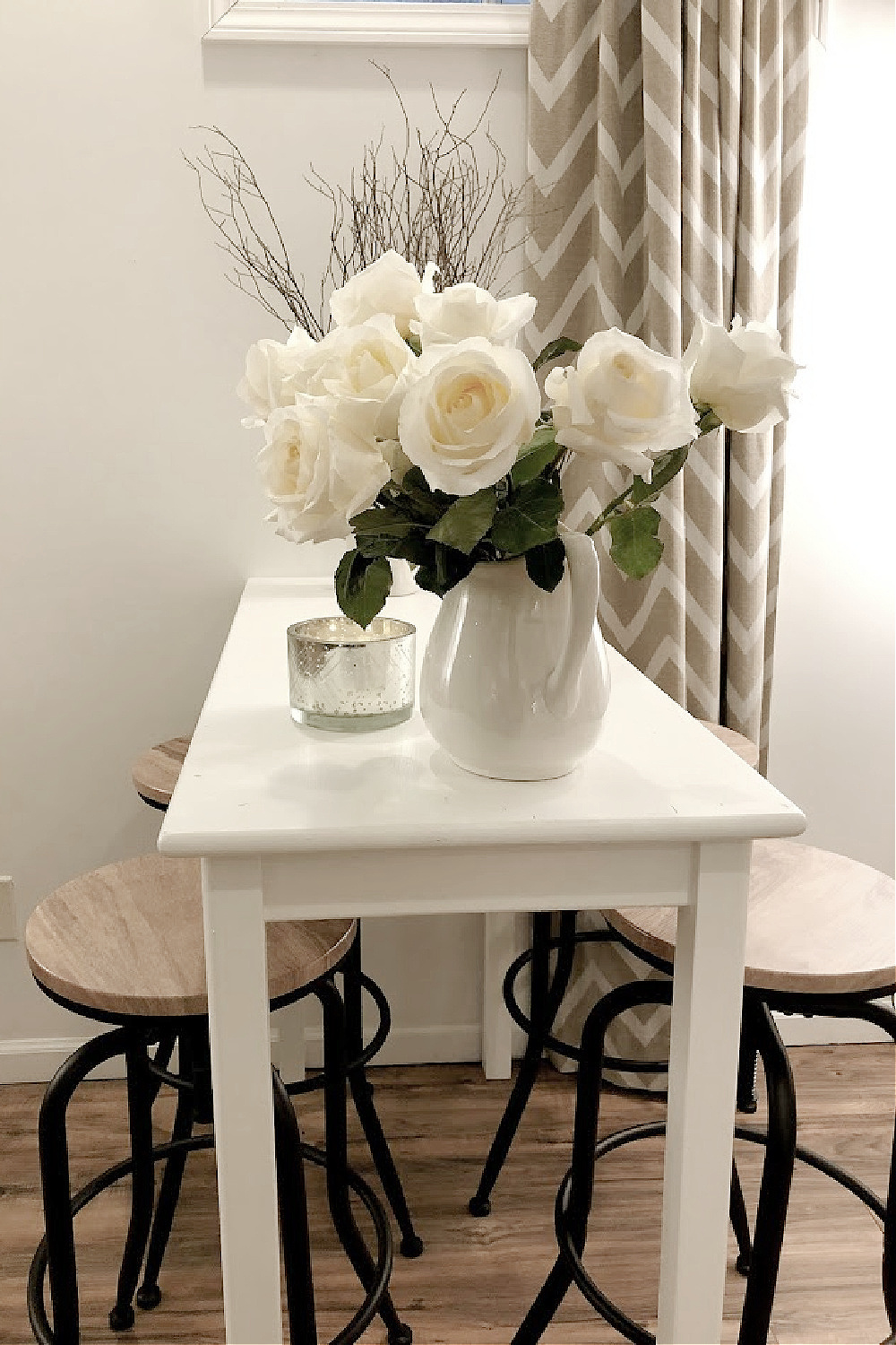 White counter height table and industrial stools with white roses - Hello Lovely Studio.