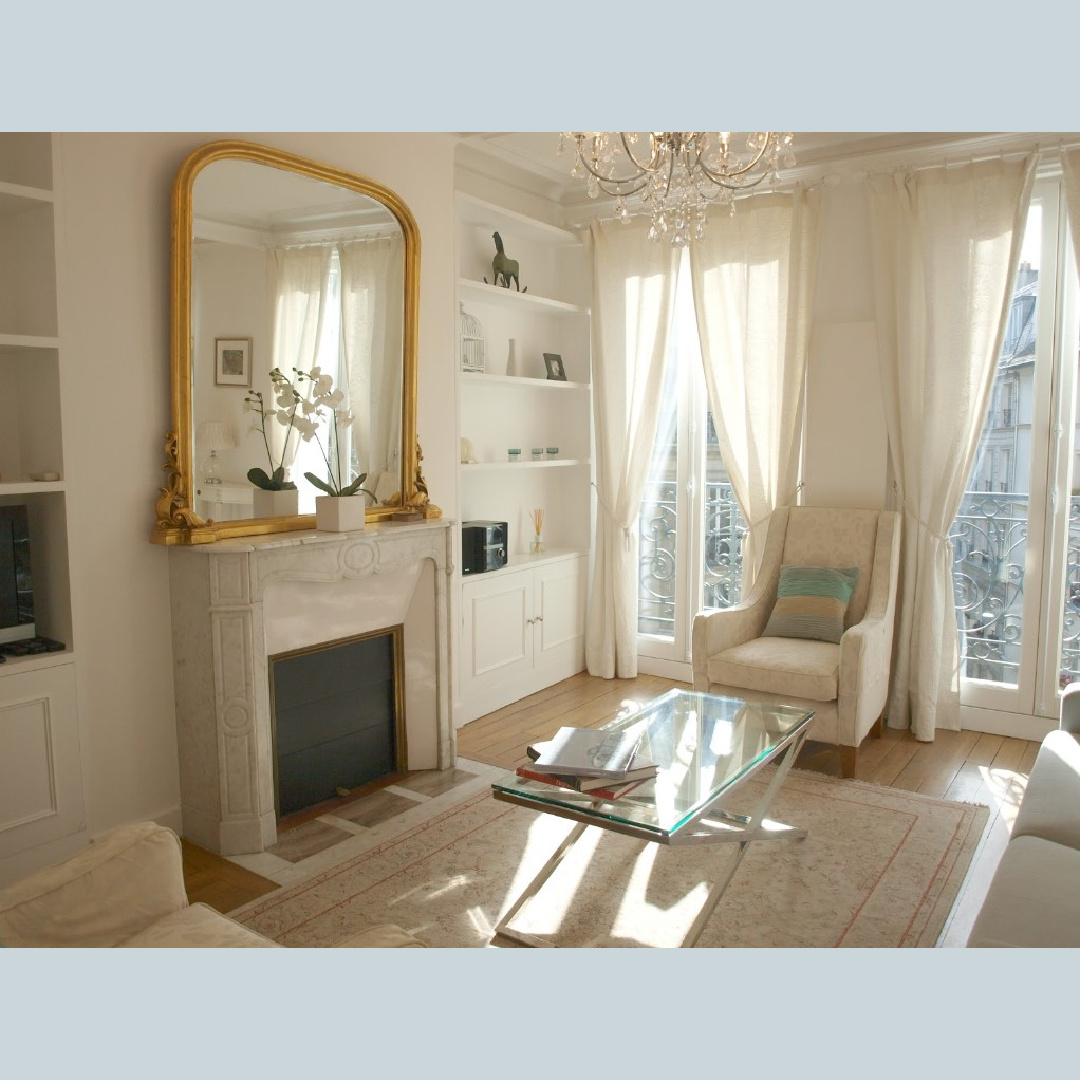 Antique French marble fireplace and built-ins in a serene Paris apartment with French doors to balconies - Haven In.