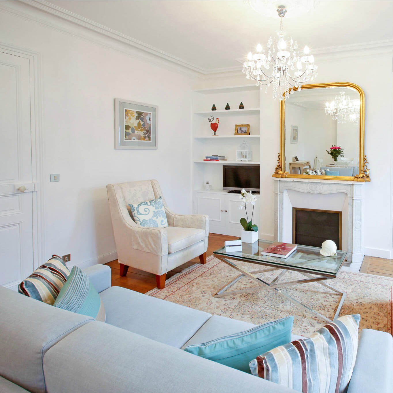 Elegant living room in a Paris apartment with antique marble fireplace and crystal chandeliers - Hello Lovely Studio