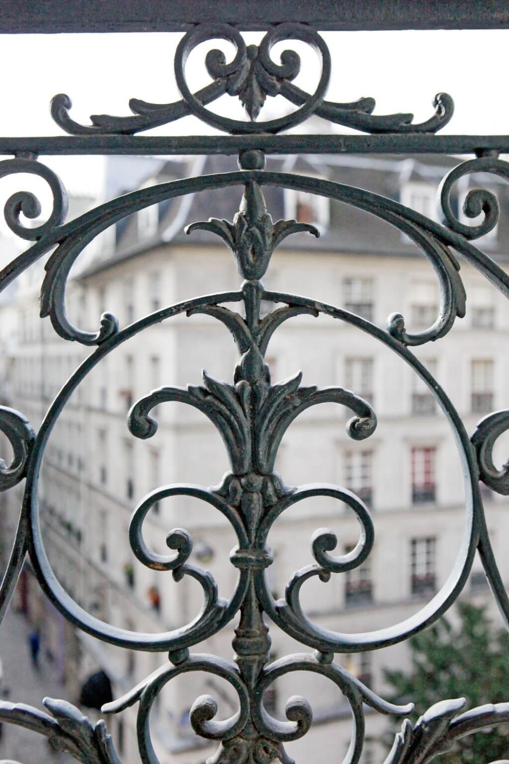 Wrought iron design with fleur de lis on balcony of a Paris apartment near Notre Dame - Hello Lovely Studio.