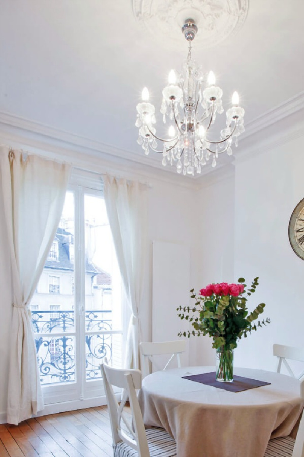 Charming dining area and crystal chandelier in a dining area with French doors to balcony in a Paris apartment near Notre Dame - Haven In.