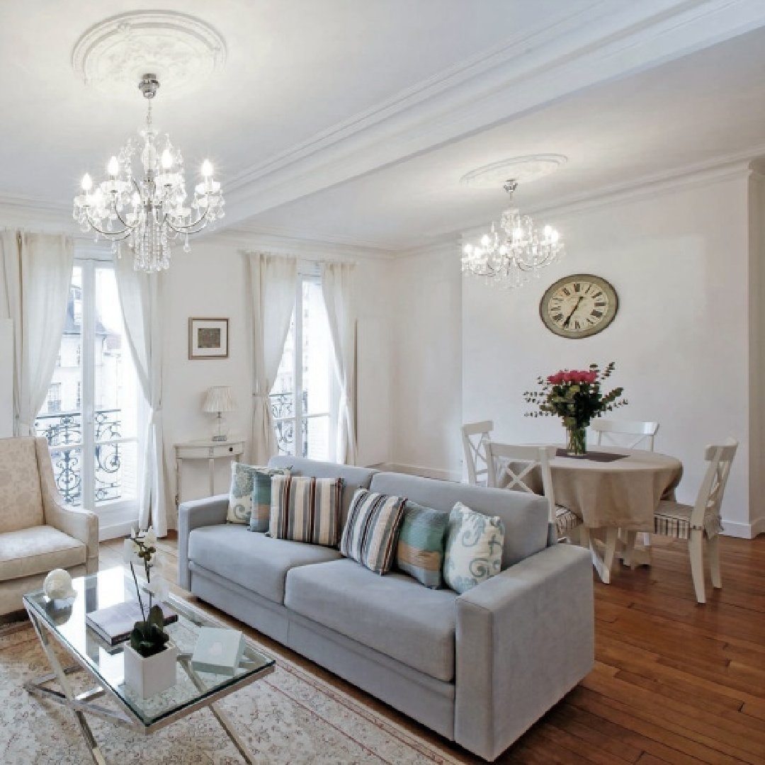 Living and dining room with French doors to balconies and crystal chandeliers in a Paris apartment near Notre Dame - Haven In.