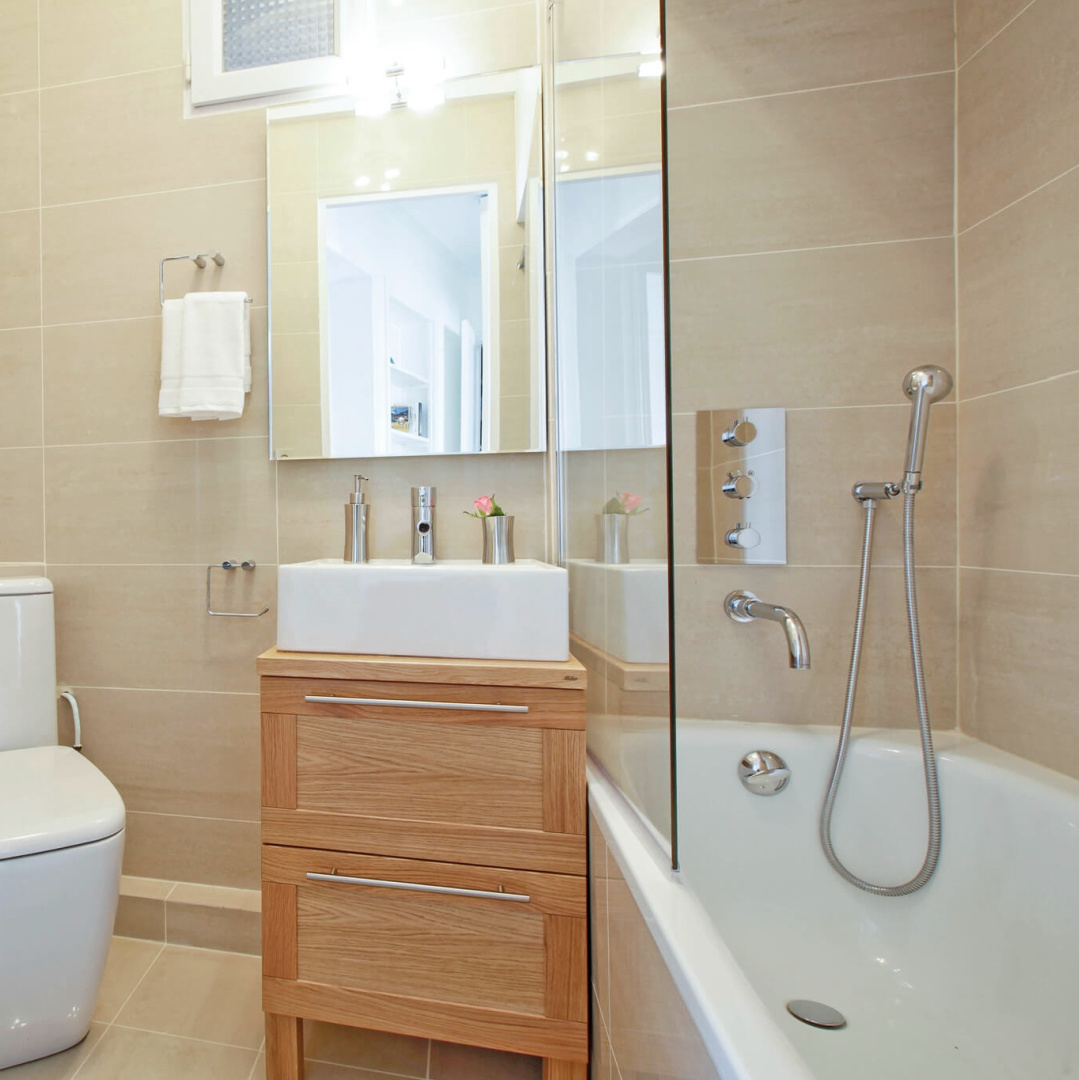 Modern bathroom in a Paris apartment with beige tiled floors and walls - Hello Lovely Studio.